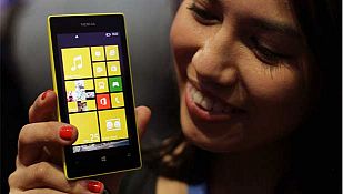 Una azafata muestra el nuevo Nokia Lumia 520, que se comercializará a partir de este año a precios "más asequibles".