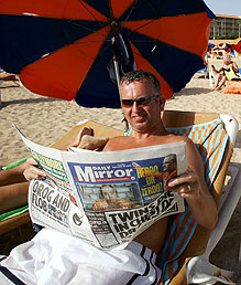 Un turista brit&aacute;nico lee el Daily Mirror en una playa de Fuerteventura.