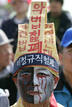 Unionised worker wearing mourning clothes takes part in May Day rally denouncing Lee governments economic policies in Seoul