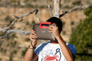 Un aficionado aplica un filtro sobre la c&aacute;mara de su tableta para fotografiar el eclipse solar