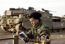 Un soldado israel&iacute; reza junto a los tanques en el norte de la Franja de Gaza.