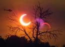Un helic&oacute;ptero sobrevuela en frente del eclipse solar en Payson, Arizona