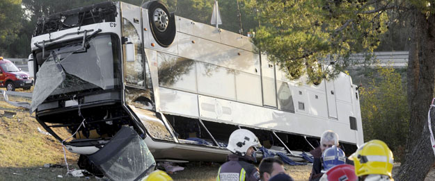 Varios bomberos permanecen junto al autobús que ha volcado en la AP-7, en el término municipal de Bàscara (Girona), c Varios bomberos permanecen junto al autobús que ha volcado en la AP-7, en el término municipal de Bàscara (Girona), c