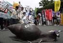 Activistas junto a la escultura de un caracol en la que se puede leer: 