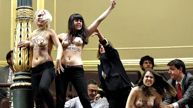 Tres mujeres con el torso desnudo interrumpen la sesión de control al grito de "aborto es sagrado"