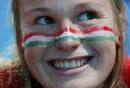 Una aficionada h&uacute;ngara sonr&iacute;e con la bandera de su pa&iacute;s pintada en la cara.