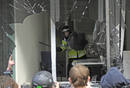 Un agente permanece detr&aacute;s de la ventana rota de una oficina del Royal Bank of Scotland en Londres.