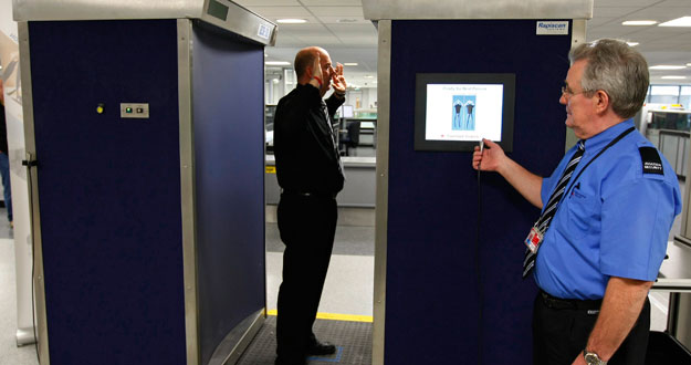 Un agente de seguridad se prepara para escanear a un compa&ntilde;ero en uno de los nuevos esc&aacute;neres corporales de cuerpo entero en el aeropuerto de Manchester.