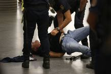 Agentes de polic&iacute;a detienen a uno de los miembros del piquete informativo en Atocha