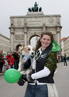 Un mujer y su perro posan para una foto delante de la Puerta de la Victoria durante el desfile del D&iacute;a de San Patricio en Munich.