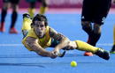 El australiano Kieran Govers golpea la bola durante la semifinal de hockey, Alemania vs Australia.