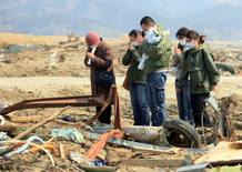 Familiares de una v&iacute;ctima del tsunami rezan en el lugar donde un alumno de la escuela primaria Otawa fue encontrado muerto, a unos 50 metros de la escuela, hoy, mi&eacute;rcoles 13 de abril de 2011 en Ishinomaki, prefectura de Miyagi (Jap&oacute;n)