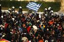 Anti-austerity protesters wave a Greek flag in front of the heavily guarded parliament in Athens Syntagma square during a demonstration