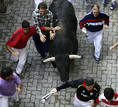Runners lead a bull towards the bullring during the fourth bull run of the San Fermin festival in Pamplona