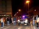 Un vehiculo de la polic&iacute;a atraviesa el cord&oacute;n policial entre vecinos de Santo&ntilde;a, tras la explosi&oacute;n de un coche bomba ocurrido esta noche junto al Patronato Militar de esta localidad c&aacute;ntabra.