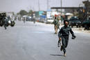 Afghan policeman runs away from the area of a suicide attack in Kabul