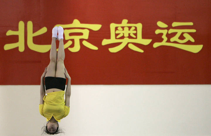 Una atleta China practica un salto desde el trampol&iacute;n en una sesi&oacute;n de entrenamiento.