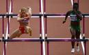 La austr&iacute;aca Beate Schrott (L) compite con la nigeriana Seun Adigun en la primera ronda femenina de100 metros con vallas durante los Juegos.