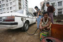 A man collects diesel from a car to be sold at an illegal market in Yangon