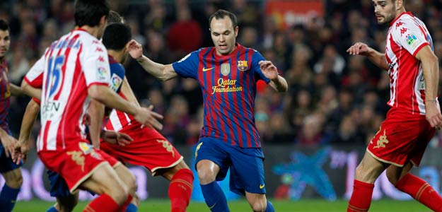 Barcelona's Iniesta is challenged by Sporting de Gijon's players during their Spanish first division soccer match at the Nou Camp stadium in Barcelona