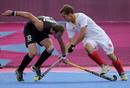 Belgiums Florent van Aubel is challenged by New Zealands Ryan Archibald during their mens group B hockey match at Riverbank Arena at the London 2012 Olympic Games