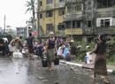 People wash up and collect water on a street in Yangon