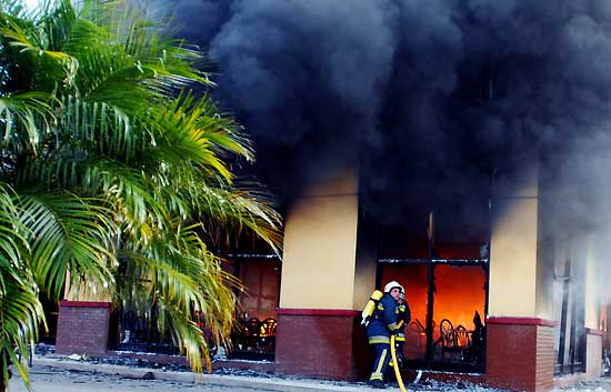 Bomberos tratan de extinguir el fuego en un restaurante de comida r&aacute;pida