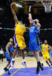 El jugador de los &Aacute;ngeles Lakers, Kobe Bryant, trata de encestar defendido por Gortat, de los Orlando Magic durante el primer partido de la final de la NBA.