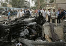 Burnt bodies in an overturned car are seen after two car bombs targeting the Ministry of Justice and the Baghdad Provincial Council exploded in central Baghdad