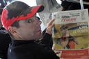 Cadel Evans lee la prensa en el aeropuerto de Grenoble donde los corredores del Tour tomaron un avi&oacute;n hacia Par&iacute;s.