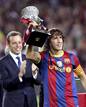 Carles Puyol levanta la copa ante los aplausos de su presidente, Sandro Rosell.