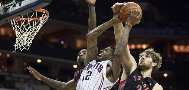 Charlotte Bobcats' Thomas goes up for a layup against Toronto Raptors' Gray and Davis during an NBA basketball game in Charlotte