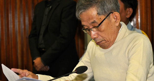 Duch lee un documento durante los argumentos finales en el juicio contra él por genocidio. Duch lee un documento durante los argumentos finales en el juicio contra él por genocidio.