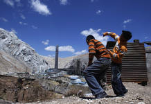 Children play on a bluff overlooking Doe Run Peru smelter in the Andean city of La Oroya
