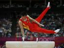 El gimnasta chino Zhang Chenglong completa el ejercicio de potro; el equipo chino ha logrado el oro en la final masculina de gimnasia art&iacute;stica.