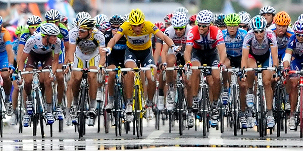 El ciclista suizo Fabian Cancellara del equipo Saxo Bank (c) hace una se&ntilde;a al resto de corredores para cruzar todos juntos la l&iacute;nea de meta.