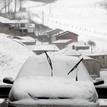 Un coche cubierto de nieve en el aparcamiento de la localidad de Pajares, en Asturias