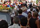 Partidarios y opositores del Gobierno acompa&ntilde;an el coche f&uacute;nebre que lleva los restos mortales de Pay&aacute;.
