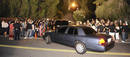 Una comitiva de coches pasa entre los fans congregados a las puertas de la residencia de la familia Jackson.