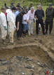 Commander of Colombias National Police Naranjo and prosecutors look at a mass grave in Turbo province