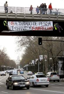 Dos activistas pro saharauis cuelgan desde un puente sobre el madrile&ntilde;o Paseo de la Castellana una pancarta con el lema: "No al Tratado de pesca UE-Marruecos. S&aacute;hara libre"