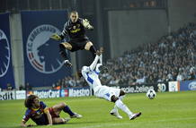 El jugador Dame N' Doye del Copenhagen choca contra el arquero del Barcelona Victor Valdes.