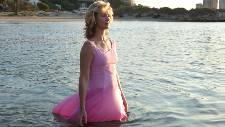 "La mujer y la tierra" ha concluido con una escena que ya apunta a convertirse en la más memorable de la temporada: Mercedes, con un vestido rosa, recorre una playa solitaria y se adentra en el mar, lentamente, mientras despunta el día. De fondo, la "La mujer y la tierra" ha concluido con una escena que ya apunta a convertirse en la más memorable de la temporada: Mercedes, con un vestido rosa, recorre una playa solitaria y se adentra en el mar, lentamente, mientras despunta el día. De fondo, la
