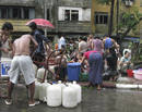 Los damnificados por el ciclón ’Nargis’ recogen agua en una calle de Yangon