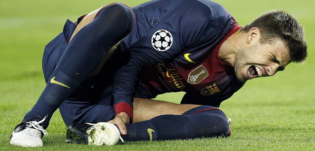 El defensa del Barcelona Gerard Piqu&eacute; se duele en el suelo tras lesionarse
