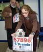 La propietaria de la administraci&oacute;n N&ordm; 271 de Barcelona, Mar&iacute;a Angels, muestra con su perro el n&uacute;mero 57.896, premiado con el cuarto premio de la Loter&iacute;a de Navidad