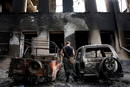 Un soldado pasa frente a carros destru&iacute;dos en una de las calles de Tskhinvali (Georgia). Las autoridades de Oset&iacute;a del Sur declararon que aproximadamente el 80 por ciento de la poblaci&oacute;n abandon&oacute; la localidad tras el ataque de Georgia.