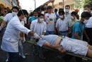 Un grupo de m&eacute;dicos sacan a un herido tras los enfrentamientos entre la polic&iacute;a y jovenes opositores al Gobierno de Morales.