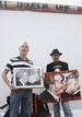 Russian artist Dmitry Vrubel and photographer Regis Bossu pose before restoration work on a segment of the East Side Gallery in Berlin