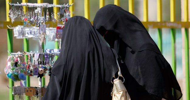 Dos mujeres vestidas con velos compran accesorios en un puesto ambulante en Sanaa en Yemen.
